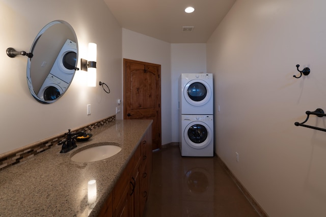 interior space featuring stacked washing maching and dryer and sink