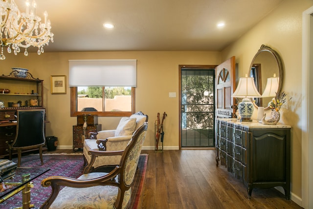 living area featuring an inviting chandelier and dark hardwood / wood-style flooring