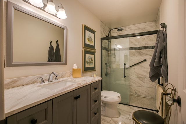 bathroom featuring a shower with shower door, vanity, and toilet