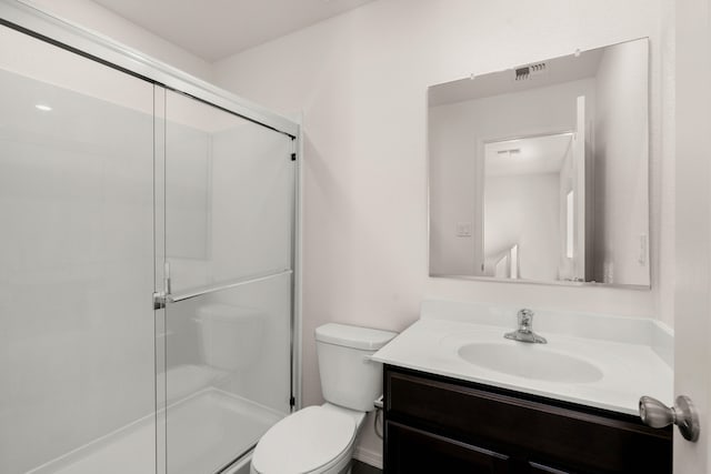 bathroom featuring vanity, toilet, and a shower with door