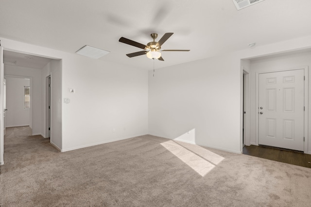 empty room with ceiling fan and dark colored carpet