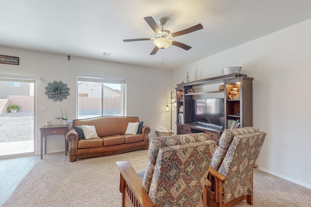 carpeted living room with ceiling fan