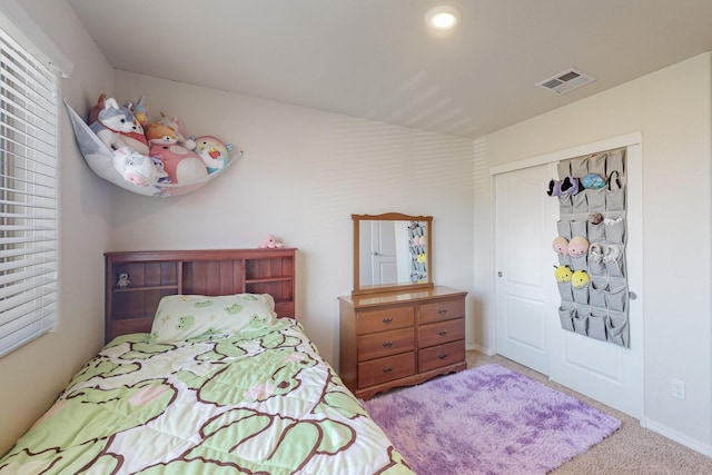 bedroom featuring light colored carpet and a closet