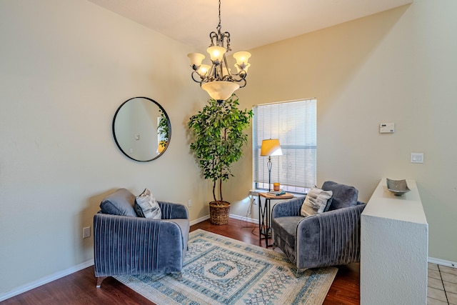 sitting room with dark hardwood / wood-style floors and a notable chandelier