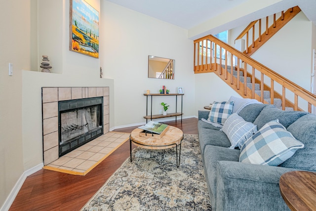 living room featuring light wood-type flooring and a tiled fireplace