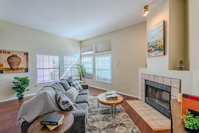 living room with a fireplace, light hardwood / wood-style flooring, and a textured ceiling