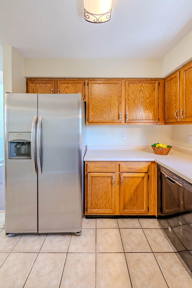 kitchen featuring light tile patterned flooring, stainless steel fridge, and dishwasher