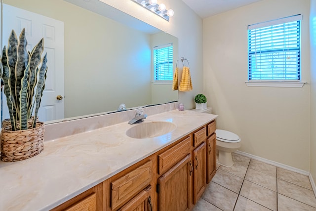 bathroom featuring plenty of natural light, tile patterned floors, vanity, and toilet