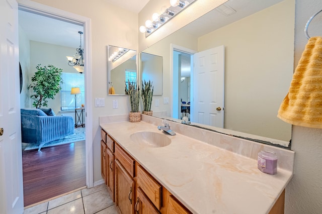 bathroom with a chandelier, vanity, and wood-type flooring