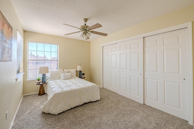 carpeted bedroom featuring a closet, a textured ceiling, and ceiling fan