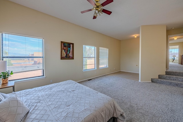 bedroom featuring multiple windows, ceiling fan, and carpet floors