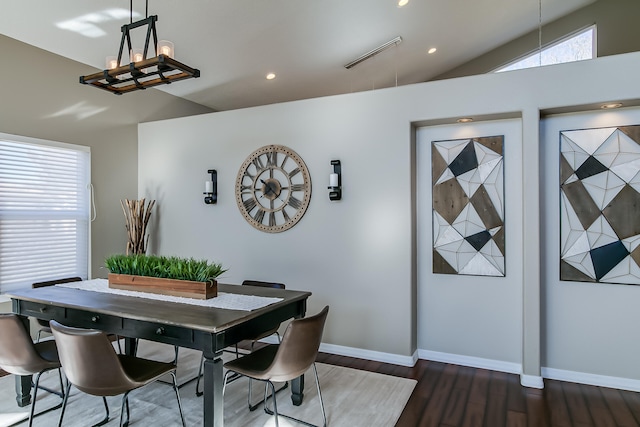 dining area featuring dark wood-type flooring and lofted ceiling