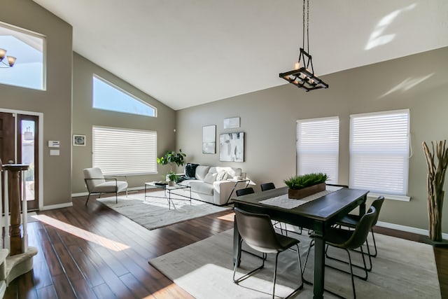 dining space featuring high vaulted ceiling and dark hardwood / wood-style floors