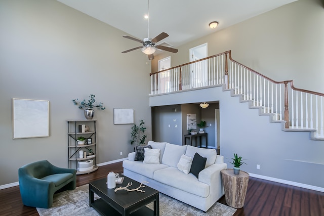 living room featuring hardwood / wood-style floors, ceiling fan, and a high ceiling