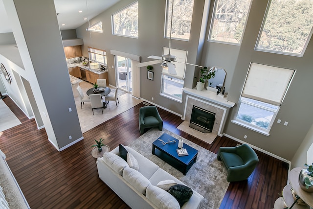 living room featuring a high ceiling, plenty of natural light, ceiling fan, and hardwood / wood-style floors