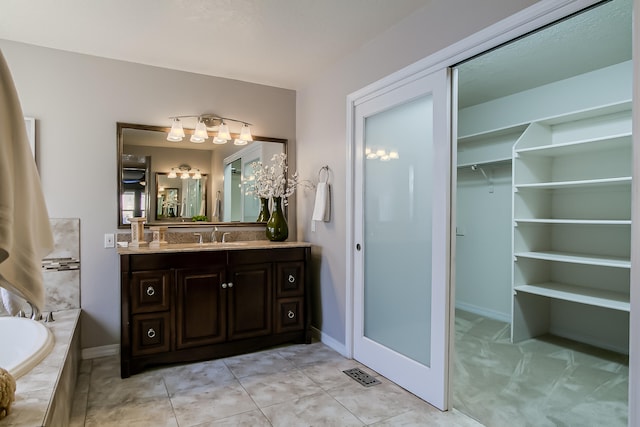 bathroom featuring tiled bath and vanity