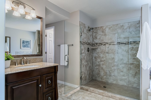 bathroom featuring a shower with door, vanity, and tile patterned flooring