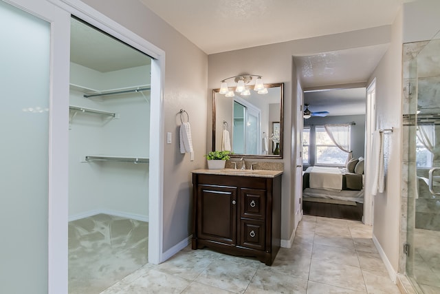 bathroom with tile patterned flooring, vanity, an enclosed shower, and ceiling fan