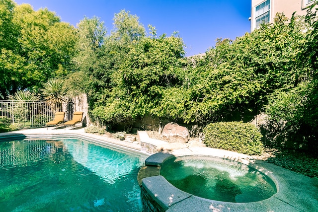 view of pool featuring an in ground hot tub