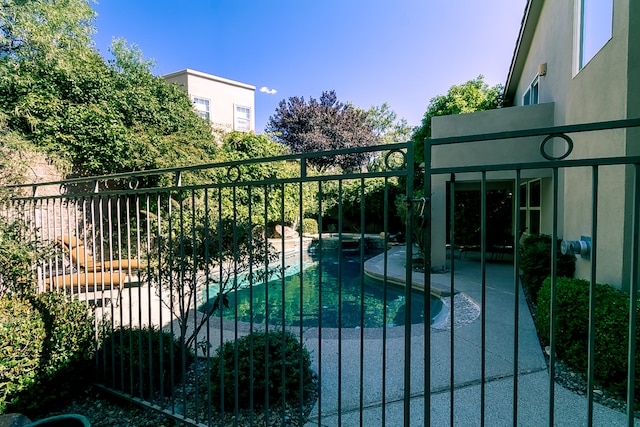 view of gate featuring a fenced in pool and a patio area