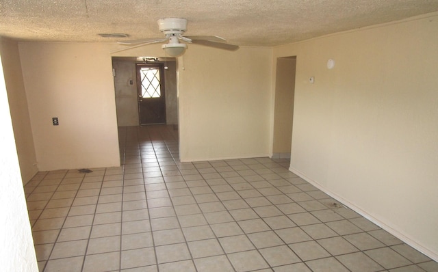 tiled spare room featuring a textured ceiling and ceiling fan