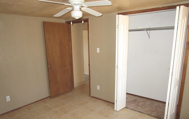 unfurnished bedroom with ceiling fan and a closet