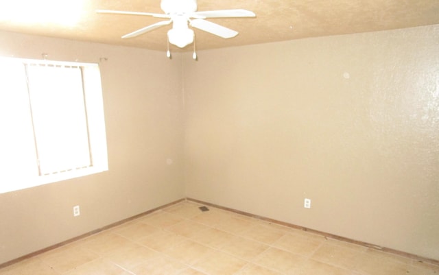 empty room featuring ceiling fan and a wealth of natural light