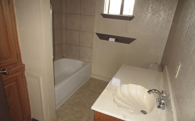 bathroom featuring tile patterned floors, vanity, and tiled shower / bath