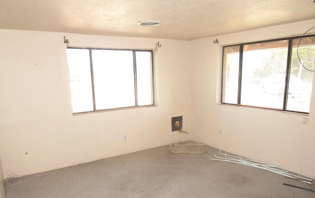 carpeted empty room with a textured ceiling