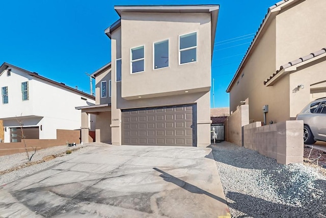 contemporary house featuring driveway, an attached garage, and stucco siding