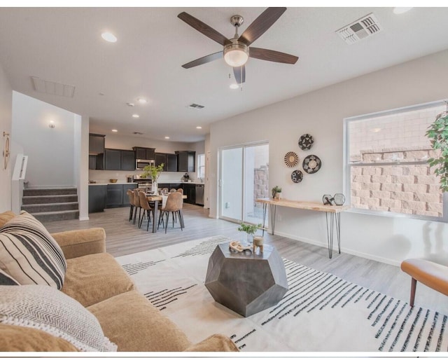 living room featuring ceiling fan and light hardwood / wood-style flooring