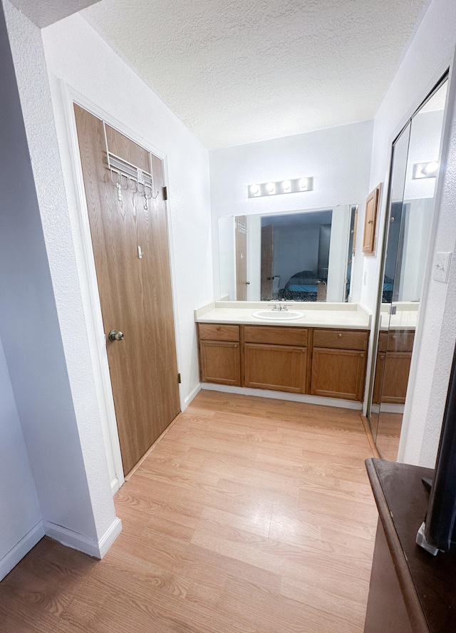 bathroom with sink, hardwood / wood-style flooring, and a textured ceiling