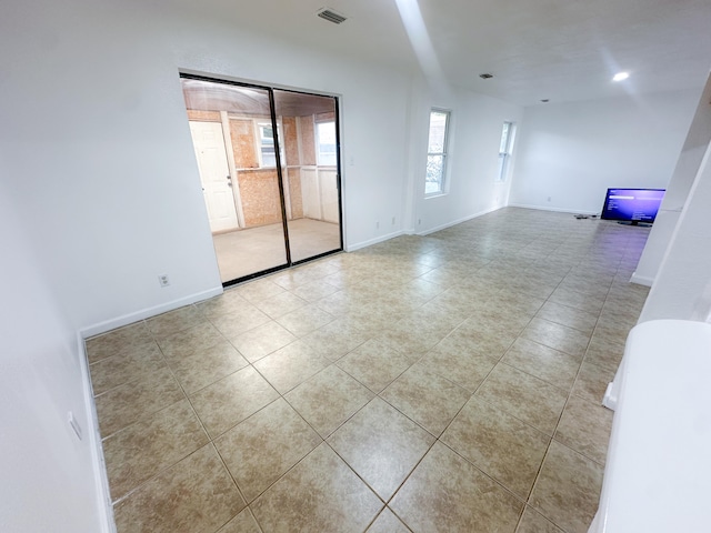 tiled spare room with a healthy amount of sunlight