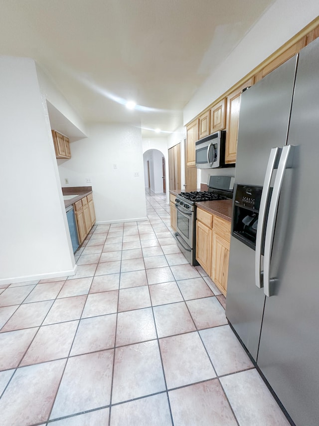 kitchen featuring appliances with stainless steel finishes, light brown cabinets, and light tile patterned flooring