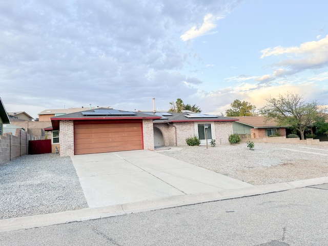 ranch-style house featuring solar panels and a garage