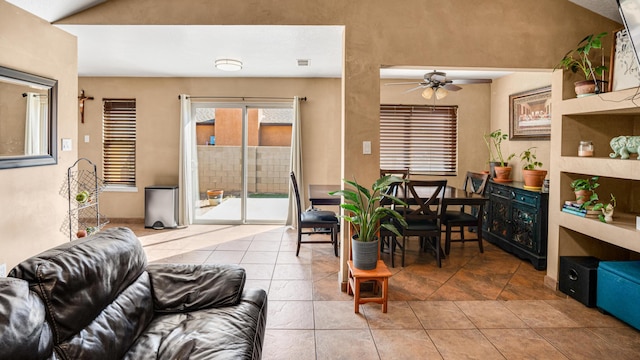 tiled dining area with vaulted ceiling and ceiling fan