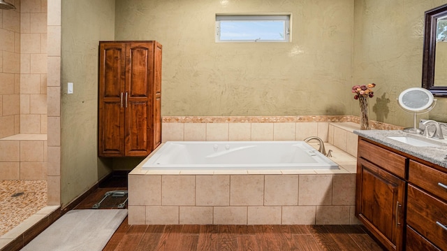 bathroom featuring vanity, plus walk in shower, and hardwood / wood-style flooring