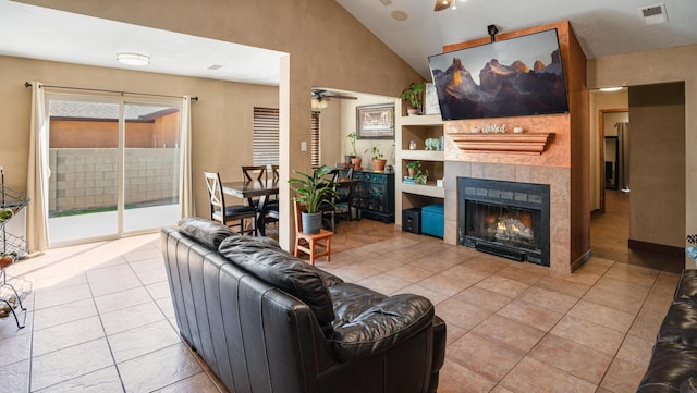 living room featuring light tile patterned flooring, ceiling fan, and a tile fireplace