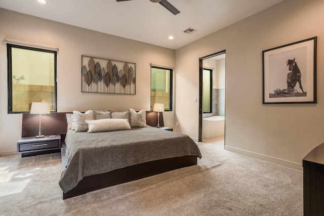 bedroom with light carpet, ensuite bathroom, and ceiling fan