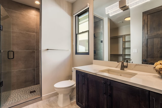 bathroom with vanity, toilet, a shower with door, and hardwood / wood-style floors