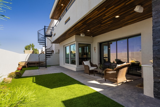 back of property featuring an outdoor hangout area, a patio, and a lawn