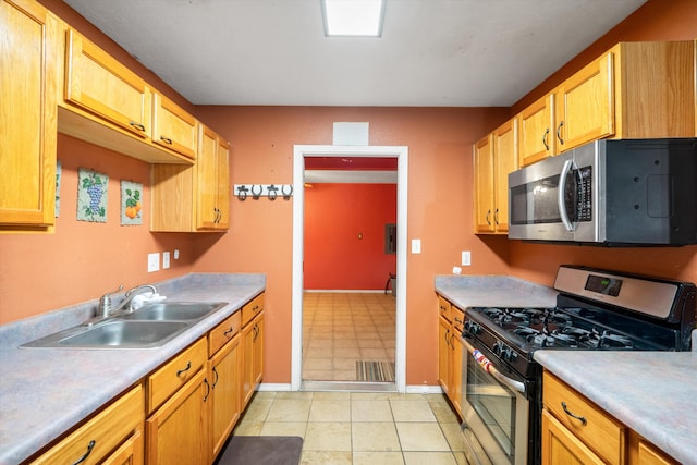 kitchen featuring sink, light tile patterned flooring, and appliances with stainless steel finishes