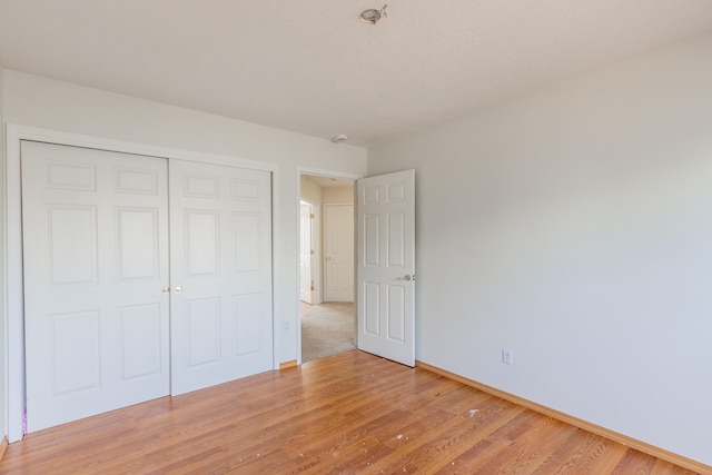 unfurnished bedroom featuring a closet and light hardwood / wood-style flooring