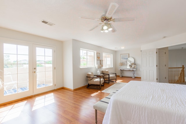 bedroom featuring french doors, ceiling fan, light hardwood / wood-style flooring, and access to outside