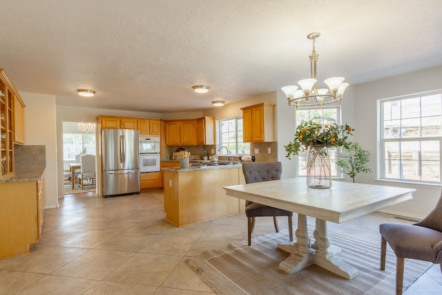 tiled dining area featuring a chandelier and a textured ceiling