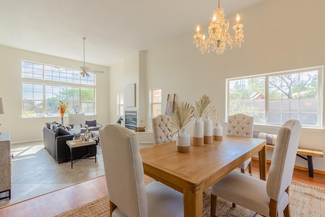 dining room with ceiling fan with notable chandelier and light hardwood / wood-style floors