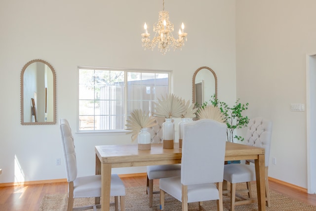 dining room with light wood-type flooring and a chandelier