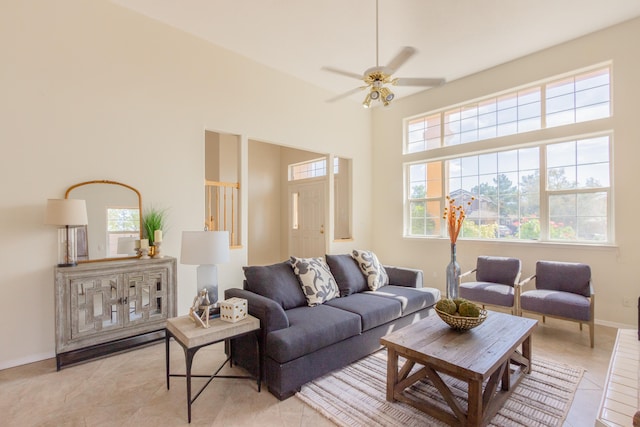 living room featuring light tile patterned flooring, a high ceiling, and ceiling fan