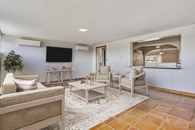 living room with a textured ceiling and a wall unit AC