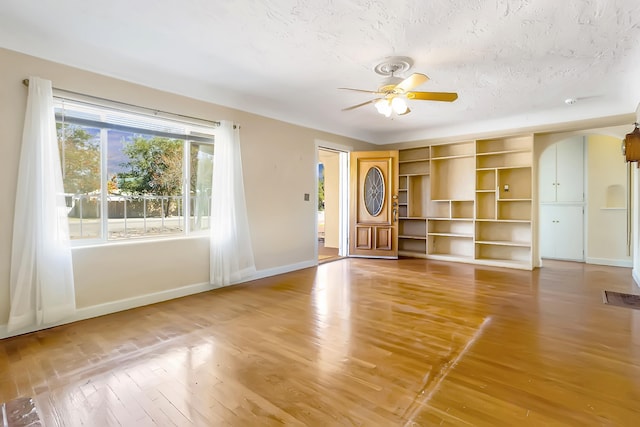 unfurnished living room featuring hardwood / wood-style floors, a textured ceiling, and ceiling fan